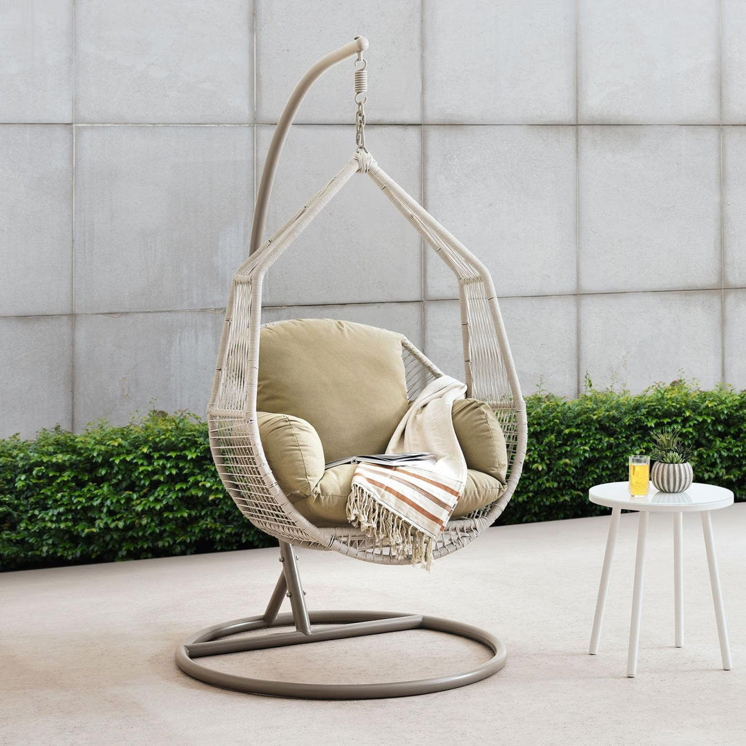 Cream outdoor egg swing chair with sturdy steel frame for patio or garden relaxation.