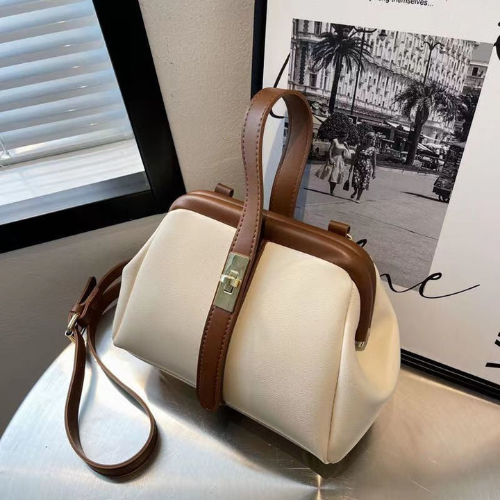 Chic black women's crossbody bag featuring an adjustable strap, top handle & structured design.