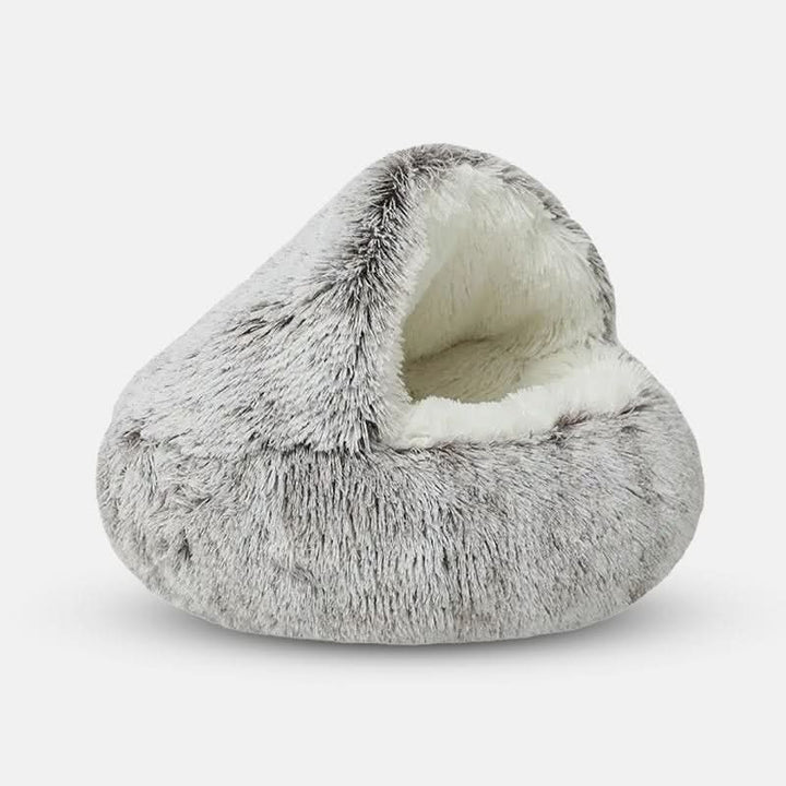 Cozy, round pet bed providing anxiety relief for dogs. Features a donut design, soft faux fur, & washable cover.