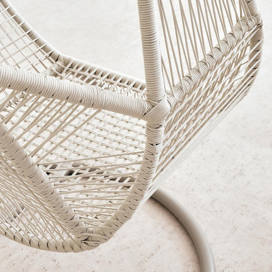 Elegant cream hanging egg chair provides luxurious outdoor seating for any garden or patio.
