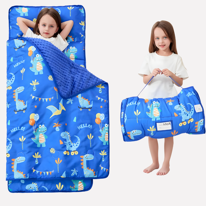 Happy toddler sleeping soundly on a soft nap mat with an attached pillow & blanket, great for daycare.