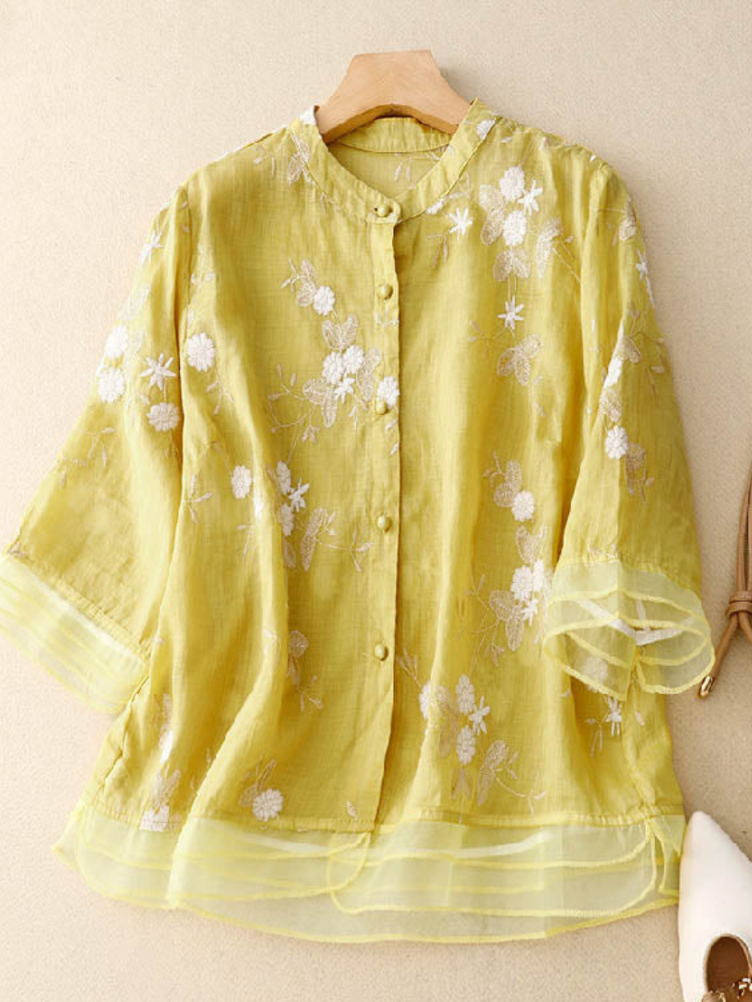 Women's fashion top: round neck, long sleeves, delicate floral embroidery, button-front.
