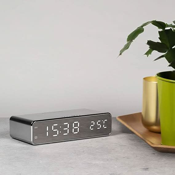 Sleek electronic alarm clock with built-in fast wireless phone charger.