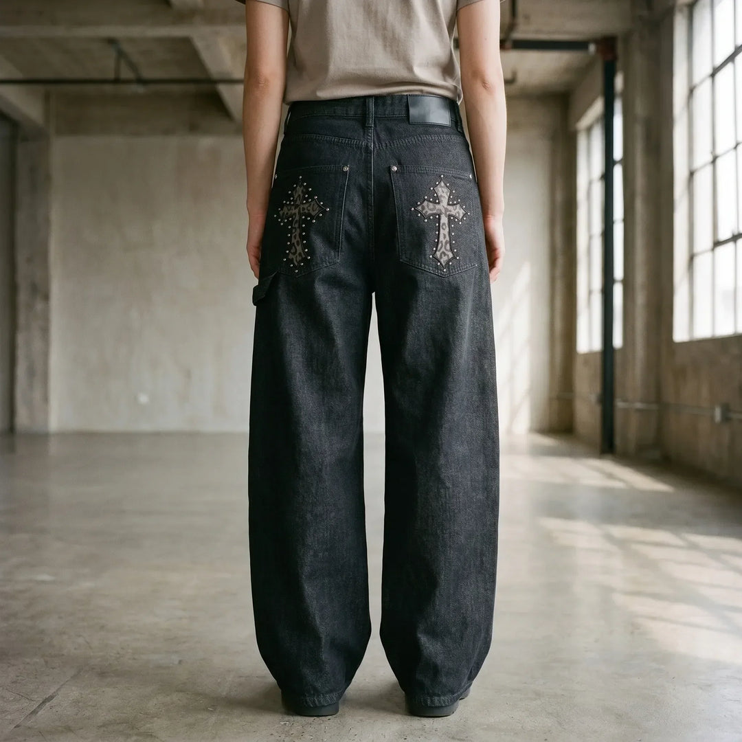 Black baggy wide-leg pants for women, featuring a studded cross design. Ideal for grunge & streetwear fashion.