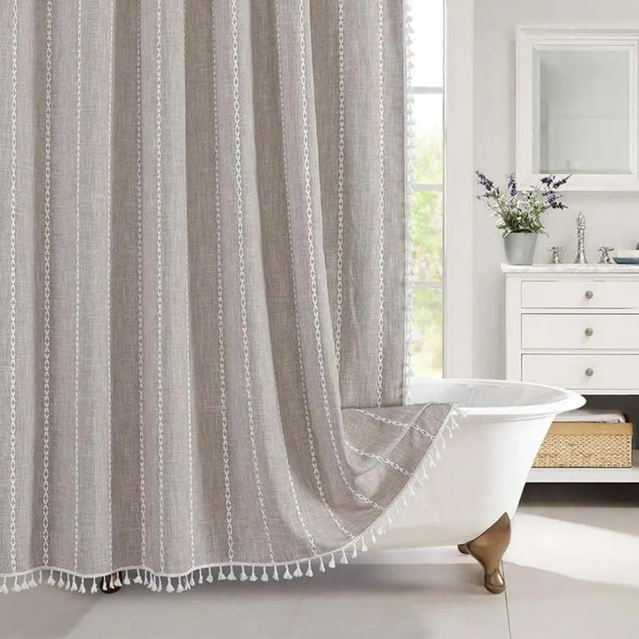 Detailed view of a striped Bohemian Farmhouse shower curtain with rustic texture and elegant tassels. Waterproof bathroom accent.