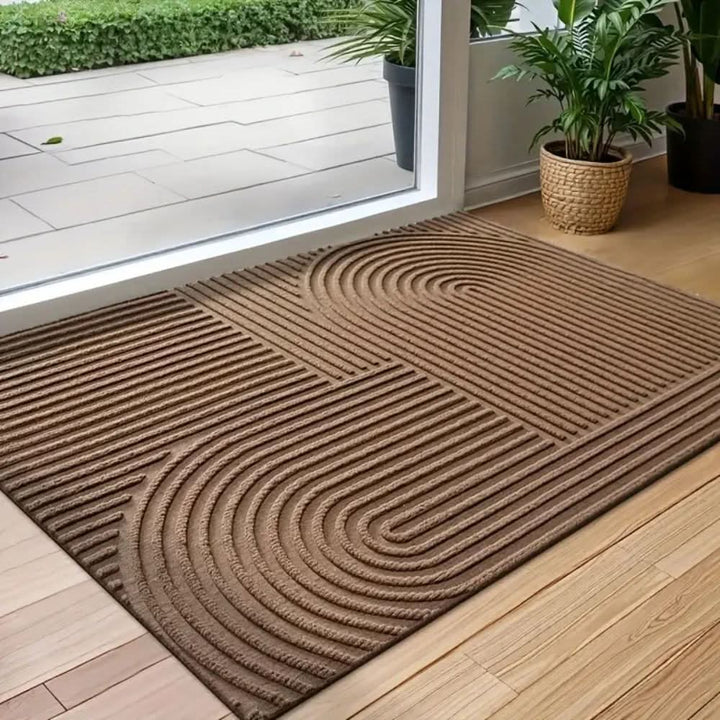 Decorative absorbent floor mat for entryways, featuring a modern flowing line pattern. Easy-care, washable.