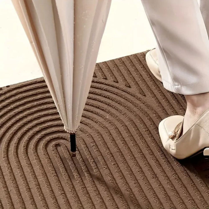 Pet-friendly absorbent entryway mat with a stylish flowing line design. Washable, non-slip floor decor.