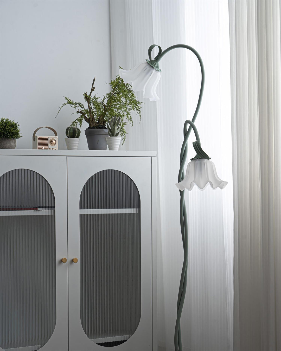 Modern green floor lamp featuring a charming floral design and a pristine white shade.