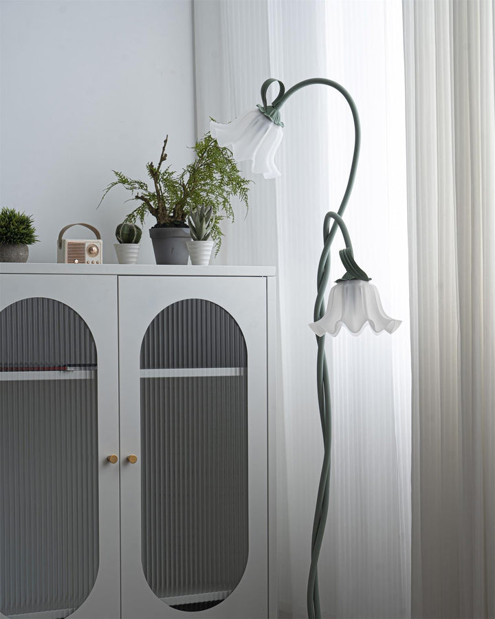 Modern green floor lamp featuring a charming floral design and a pristine white shade.