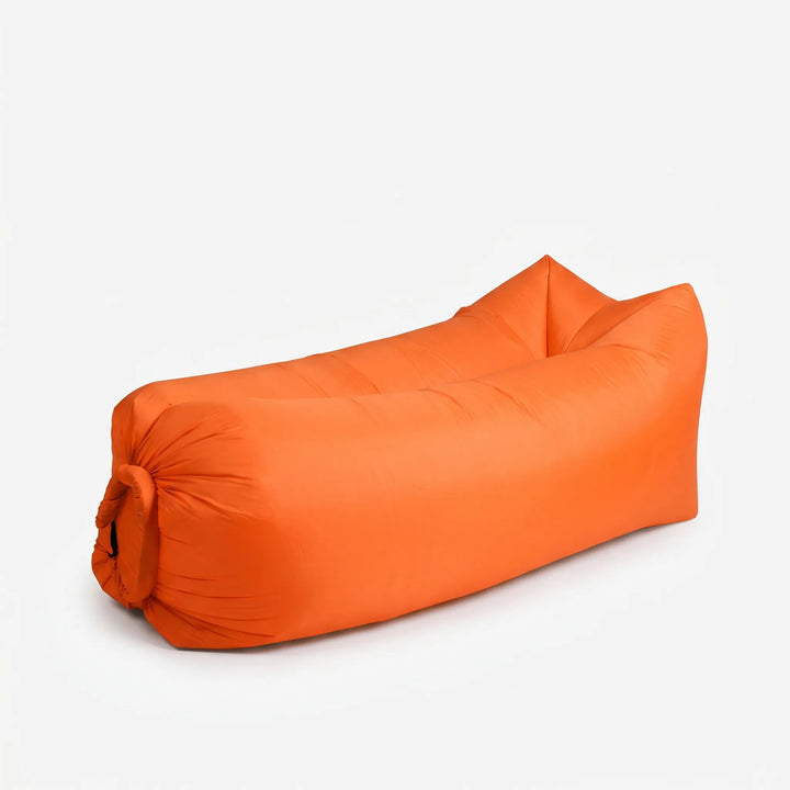 Relaxing on a sunny beach with a portable inflatable air lounger; ideal for beach comfort.