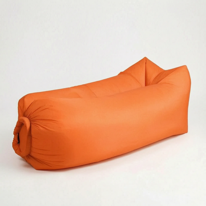 Adult enjoying a portable inflatable air lounger in a green park, perfect for outdoor seating.