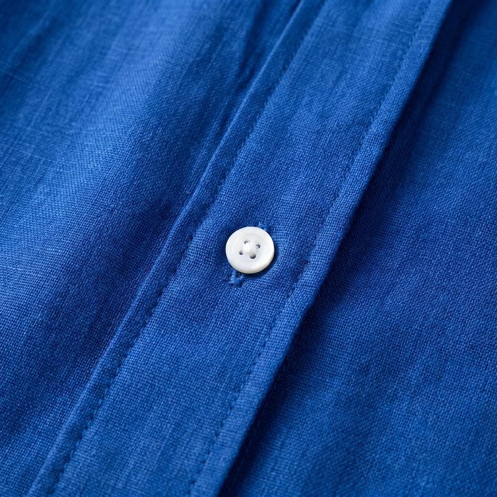 White oversized women's summer blouse with button-up detail, a lightweight, long sleeve casual top for warm weather.