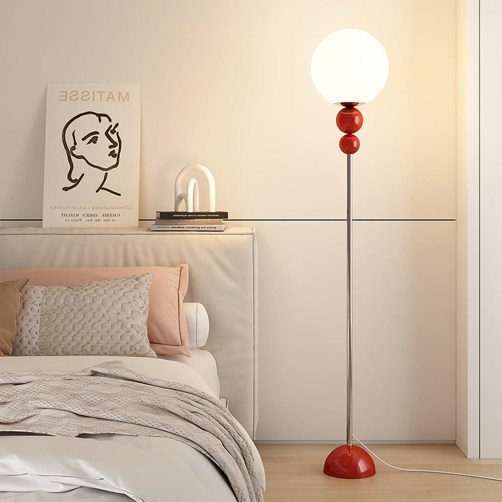 Contemporary red floor lamp, metal and glass, perfect for a cozy bedroom light.