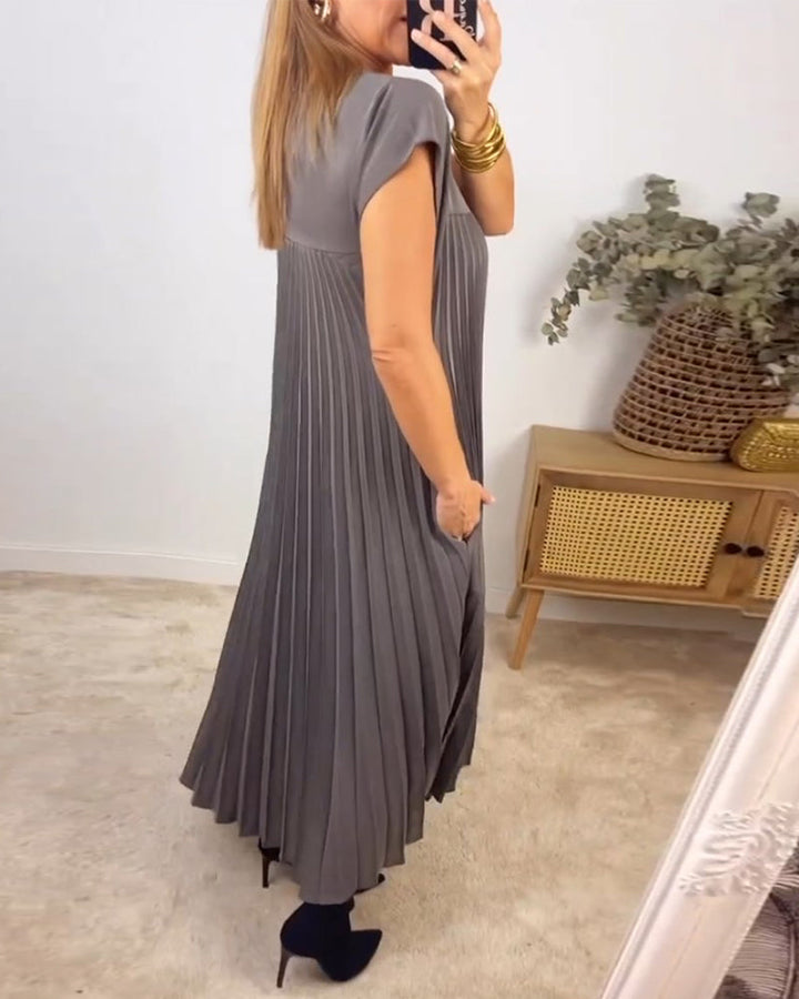 Back view of an elegant women's pleated maxi dress, highlighting its flowing lines, long design & comfortable style.