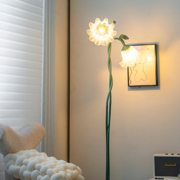 Green botanical floor lamp, detailed floral elements, white shade, modern living room.