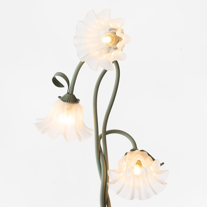 Botanical green floor lamp with stylized floral accents and a clean white shade.