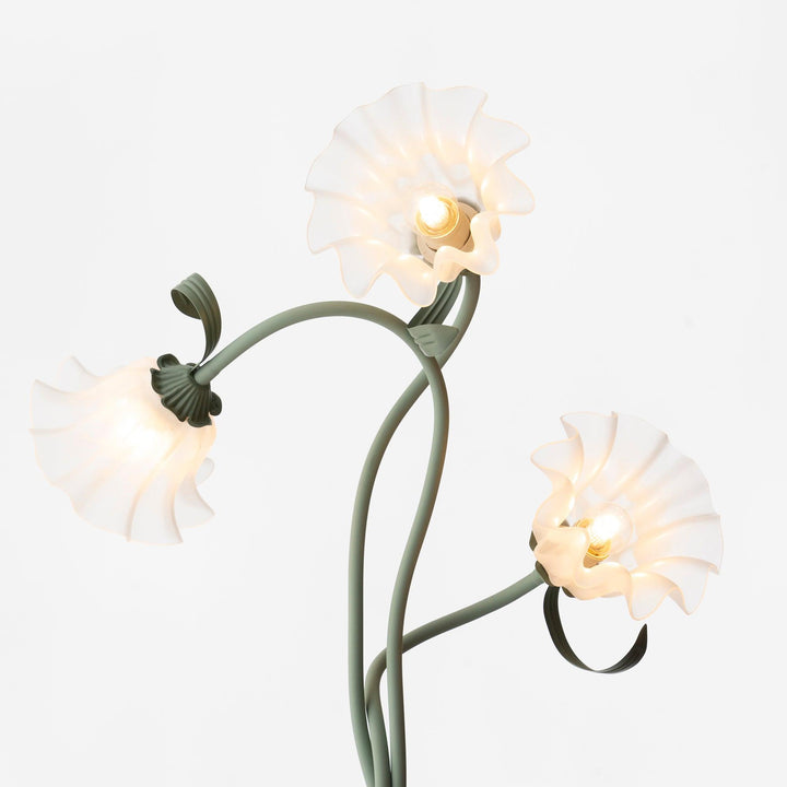 Modern green floor lamp with delicate floral patterns and a classic white shade.