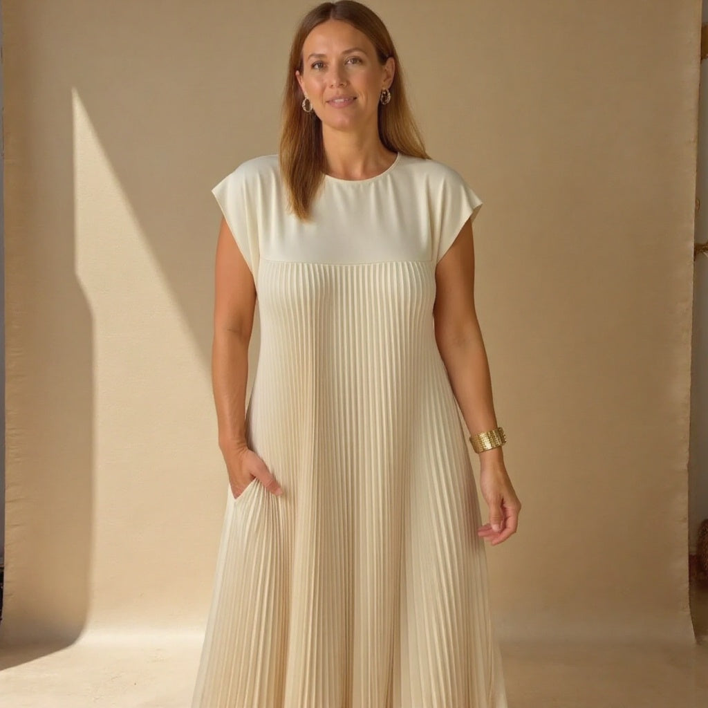 Detail shot of the flowing fabric on a women's pleated maxi dress, comfortable, elegant & versatile for summer.