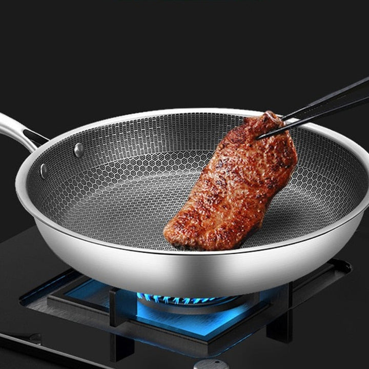 Durable stainless steel skillet with textured cooking surface for even searing.