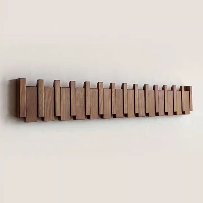 Elegant piano style wall coat rack with foldable hooks for entryway organization.