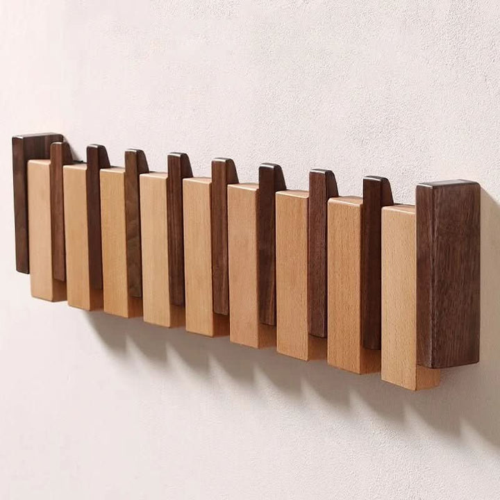 Functional entryway organizer: elegant piano style wall coat rack featuring clever foldable hooks.