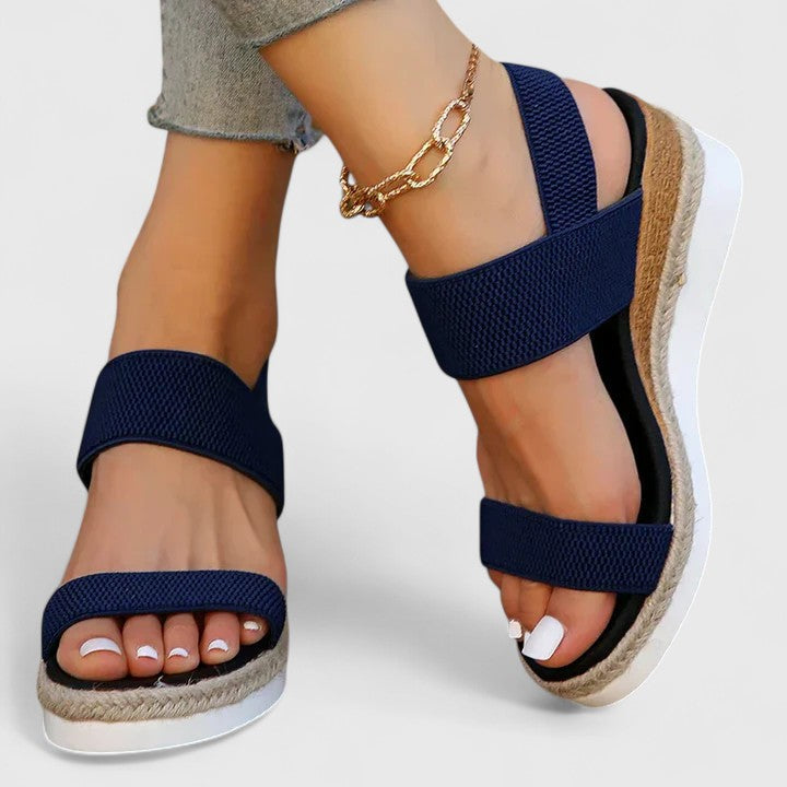 Overhead view of stylish women's orthopedic wedge sandals on a white background, arch support visible.