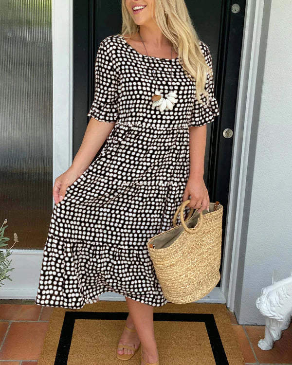 Flowy women's dotted midi dress featuring a relaxed, tiered design. Comfortable summer casual wear for any occasion.