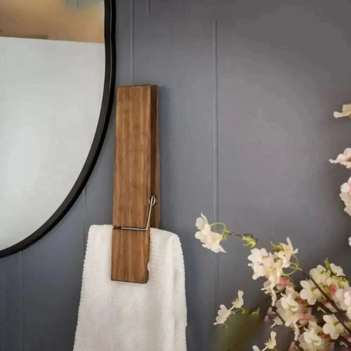 Modern natural wood towel clip for elegant bathroom decor. Wall-mounted spa accessory, perfect for home organization.