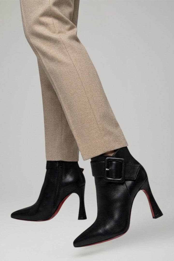 Stylish black women's ankle boots with a prominent buckle and full-length zip, offering comfort and style.
