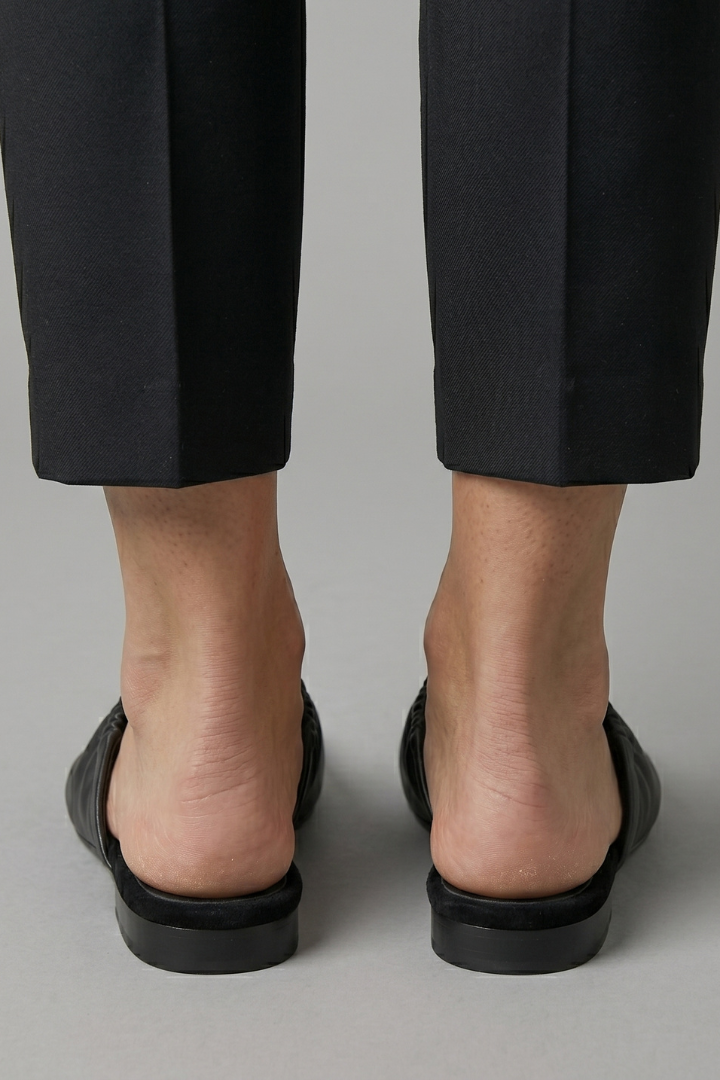 Classic black women's flat slip-on mules with a polished cap toe, offering comfort and style for daily wear.