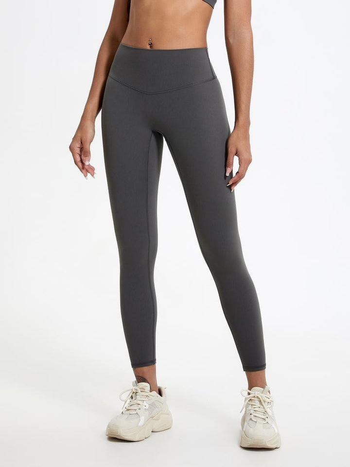 Woman modeling high-waisted sculpting leggings, flattering fit for activewear and everyday comfort