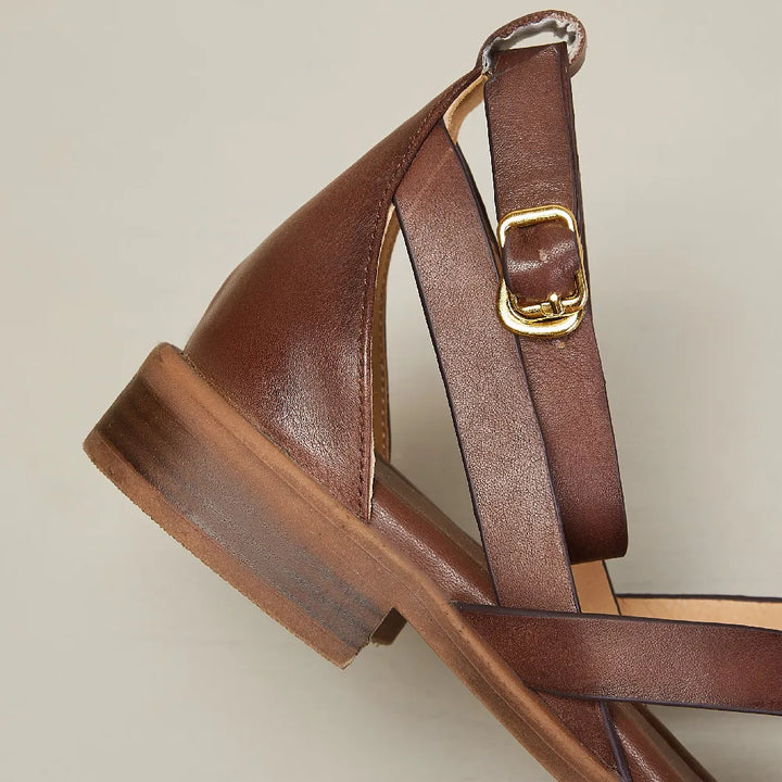 Pair of women's flat leather sandals in brown, designed for comfort and everyday wear