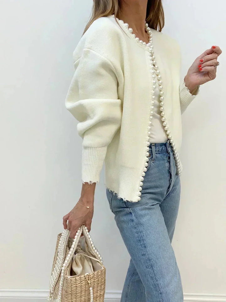 Soft knit women's cardigan featuring delicate pearl trim, a chic long-sleeve sweater for any occasion.
