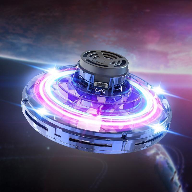 Child's hand guiding an interactive mini flying drone toy with colorful LED lights.