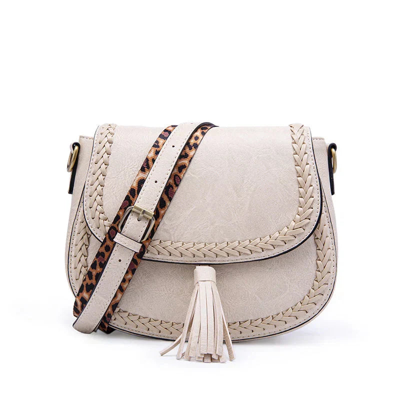 Woman wearing elegant brown saddle bag with tassel. Chic crossbody shoulder fashion accessory, perfect for everyday.