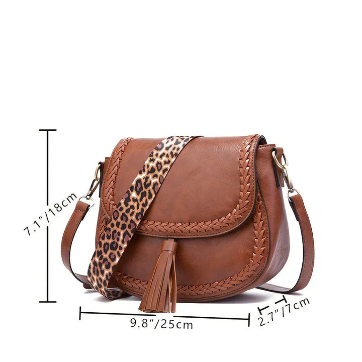 Stylish brown women's elegant saddle bag, a chic crossbody shoulder handbag with a sophisticated tassel detail.