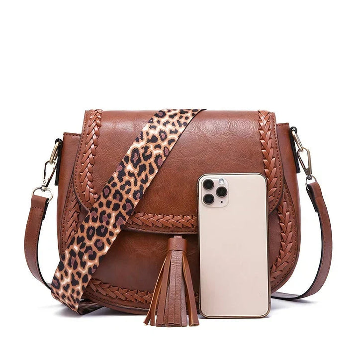 Chic white fashion accessory: women's elegant saddle bag with a stylish tassel. Versatile crossbody shoulder handbag.