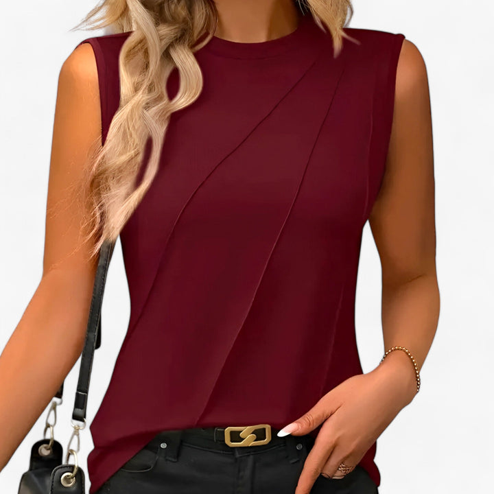 Dressy women's sleeveless blouse, designed with chic diagonal pleats. Crew neck style, perfect for elegant workwear.