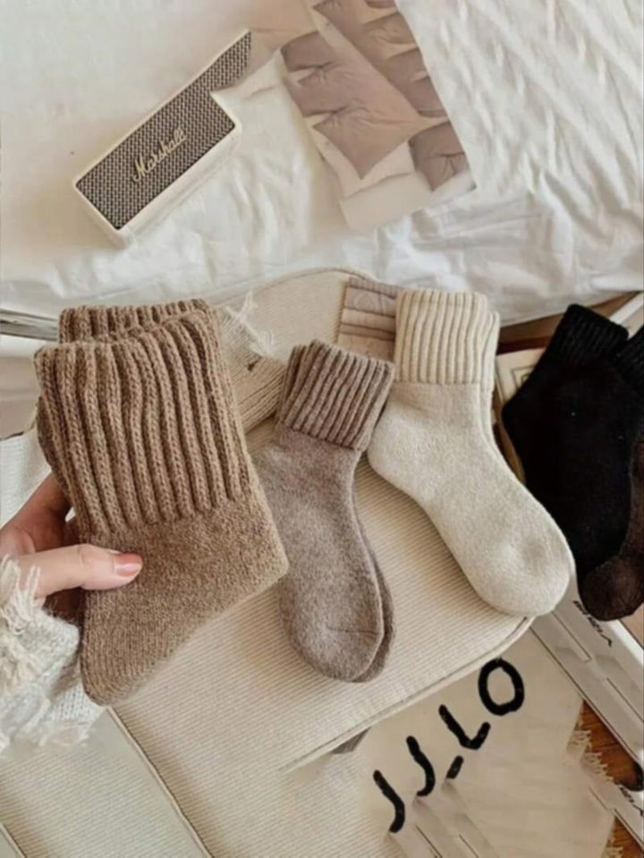Woman wearing plush cream-colored wool blend knit socks, showcasing cozy comfort