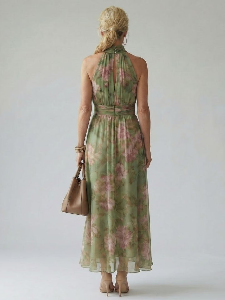 Close-up of elegant women's green halter neck midi dress featuring a vibrant bloom floral print.