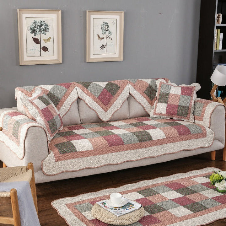 Pet-friendly, soft cotton quilted sofa protector in a neutral color, perfect for living room decor.