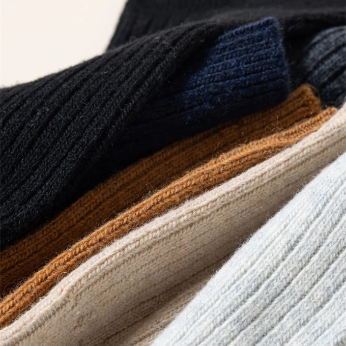 Stack of colorful knit wool winter socks, emphasizing variety and plush warmth for all.