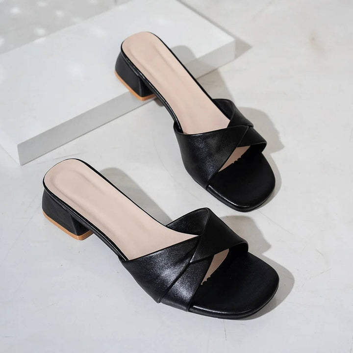 Detail shot of the modern square-toe and cross-strap design on women's elegant block heel slide sandals.