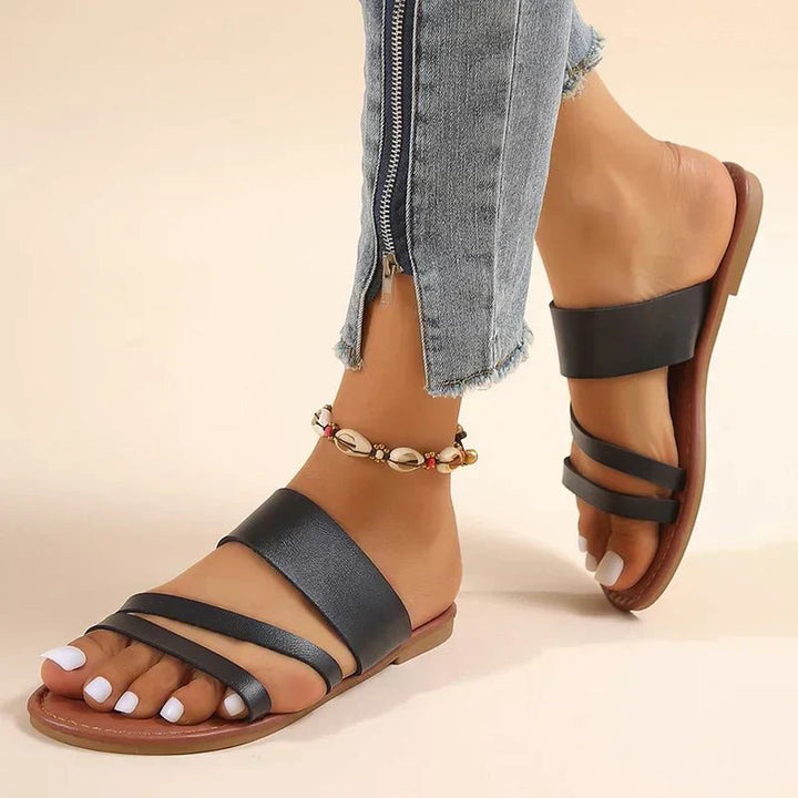 Women's cushioned cross-strap flat sandals for comfortable everyday summer wear.