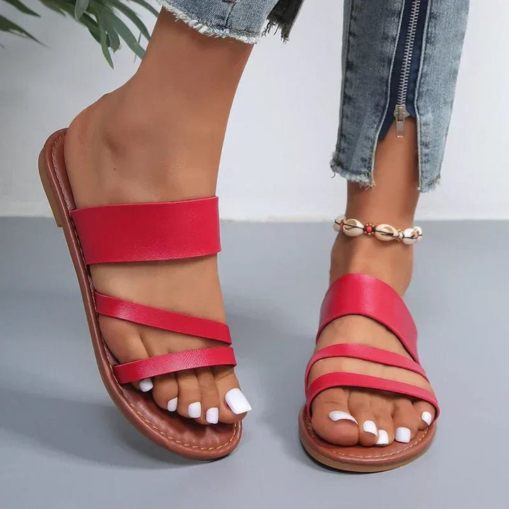 Women's comfortable slip-on flat sandals featuring a cushioned footbed and cross-straps.