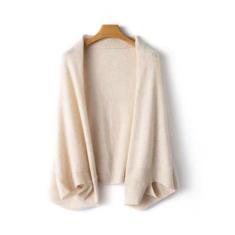 Stylish black knit shawl wrap, draped over an armchair, highlighting its texture.