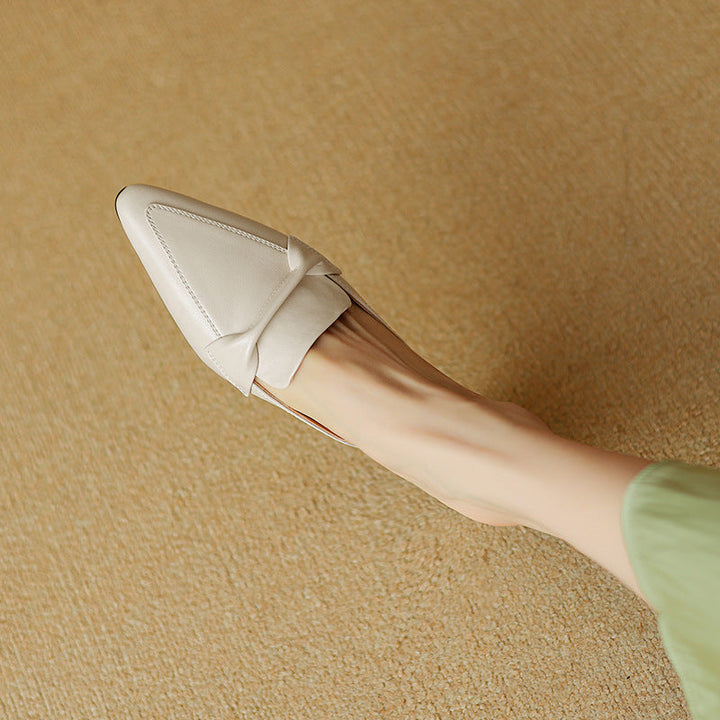 Classic white leather mules for women, detailed with a charming bow, offering comfort and style