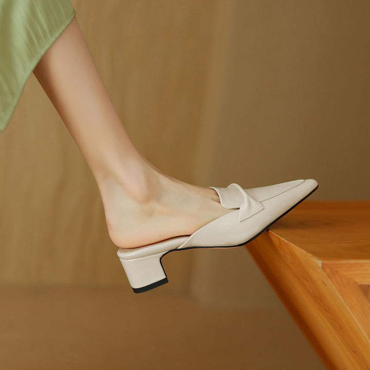 Women's brown leather bow mules in a stylish setting, emphasizing their elegant appeal