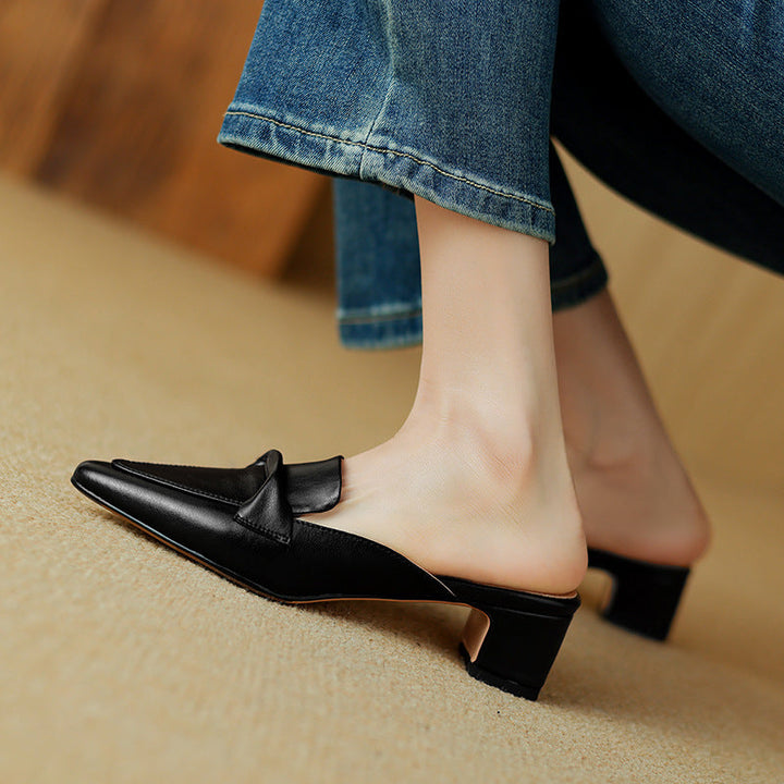Crisp white leather mules with a chic bow, showcasing comfortable and versatile design