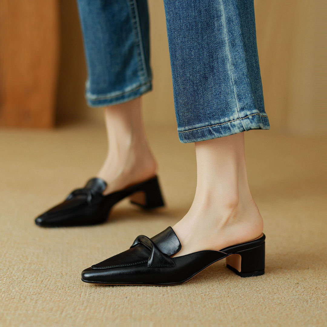 Fashionable black leather bow mules for women, providing both comfort and elegance